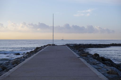 A beautiful shot of a road going to the beach under a cloudy sky in the evening