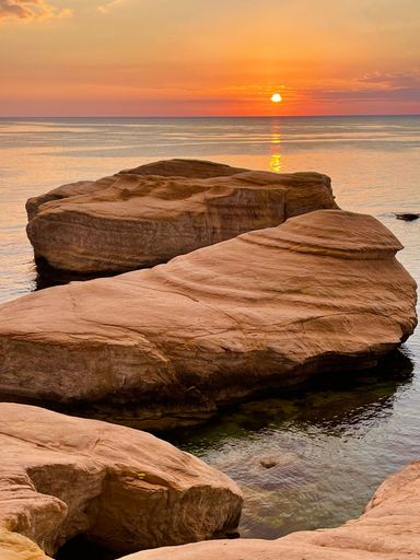 A vertical shot of large rocks on the shore of the sea in Cyprus