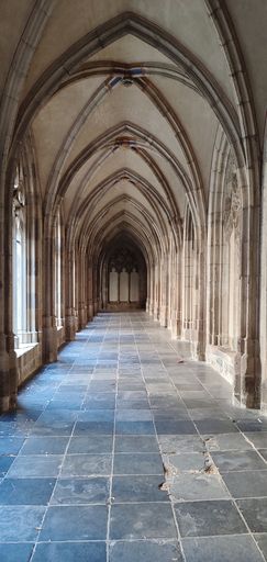 An empty, grand hallway featuring multiple ornamental arches