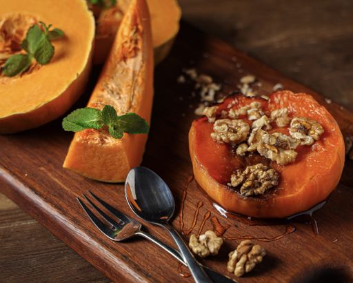 A closeup shot of oven baked pumpkin with walnuts and mint leaves on them
