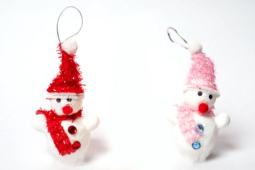 A closeup shot of two decorated snowmen in the white plain background