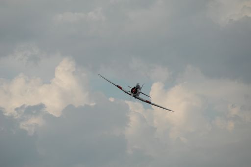 A low angle shot of a light aircraft under a cloudy sky