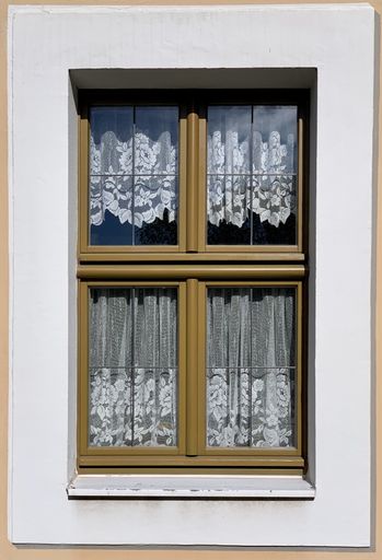A vertical shot of a window on a white wall