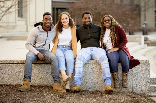 A group of people sitting in a park under sunlight with a blurry background