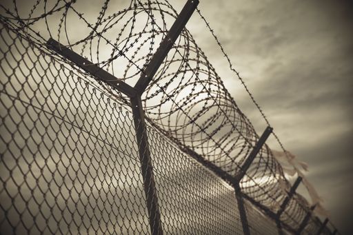 A selective focus shot of fence with barbed wire