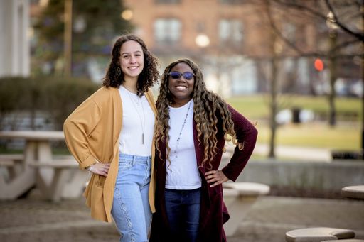 A cute selective focus shot of two friends smiling and posing together