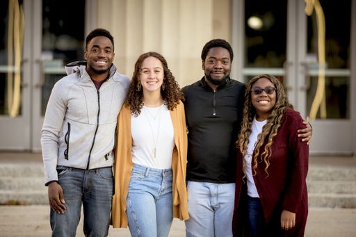 A group of people standing in a park under sunlight with a blurry background