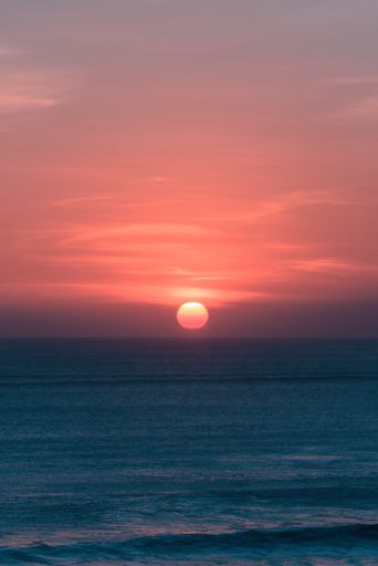 A vertical shot of the breathtaking sunset over the calm ocean