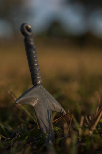 A vertical shot of a rusty sword on the grou