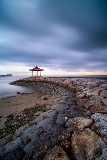 A gazebo at Karang beach, Sanur, Bali, Indonesia on background of the gloomy sky