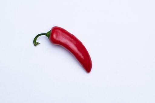 A high angle shot of a red chili pepper isolated on a white background