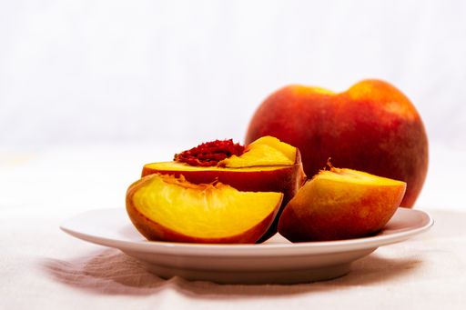 A closeup shot of fresh peach on a white plate