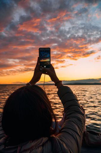 Picture of a woman taking a picture with his mobile to Albufera lake in Valencia, Spain.