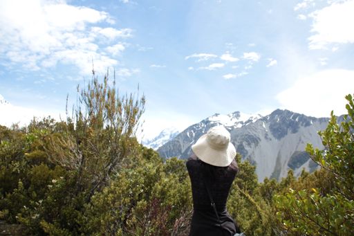 A beautiful view of a woman looking at the mountain chain covered in snow