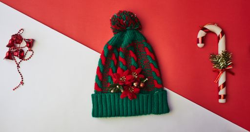 A top view of knitted Christmas hat with Christmas decorations and a medical mask - new normal