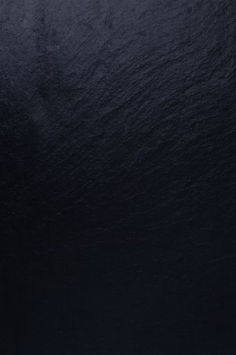 A vertical shot of a textured wall painted in black color