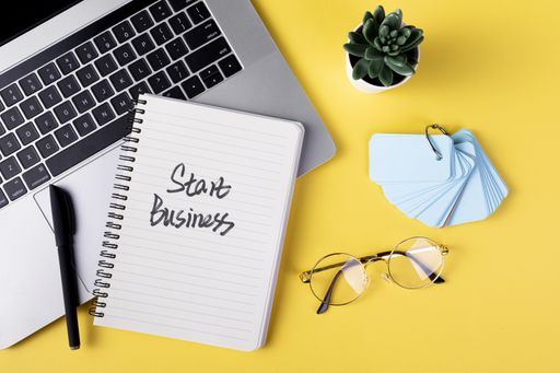 A flat lay of a notepad with a motivational schedule written on it on yellow background