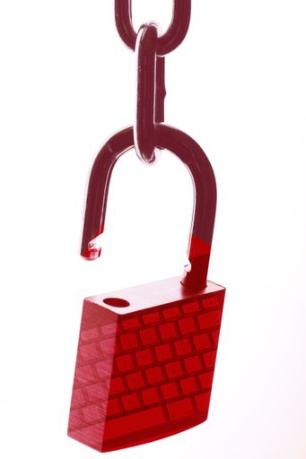 An isolated shot of a red padlock on a chain with a reflection of a keyboard on it -  web security and VPN concept