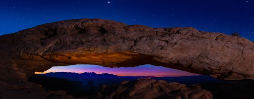 A breathtaking panoramic view of Mesa Arch in Canyonlands National park on starry night sky background
