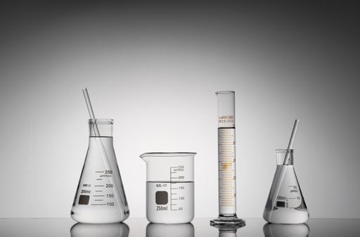 A closeup shot of transparent laboratory flasks, beakers, and tubes