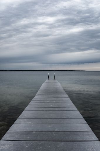 A pier over lake against cloudy sky