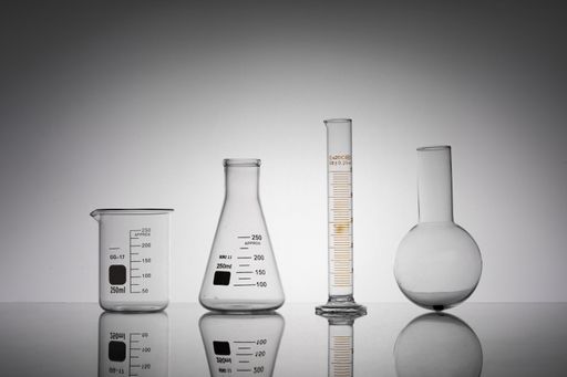 A closeup shot of laboratory flasks, beaker, and tube