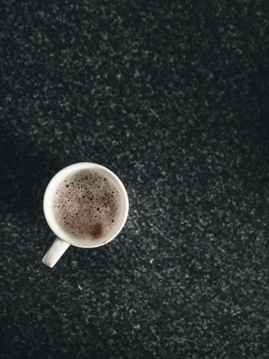 A vertical shot of a mug of coffee on the kitchen counter with a place for text
