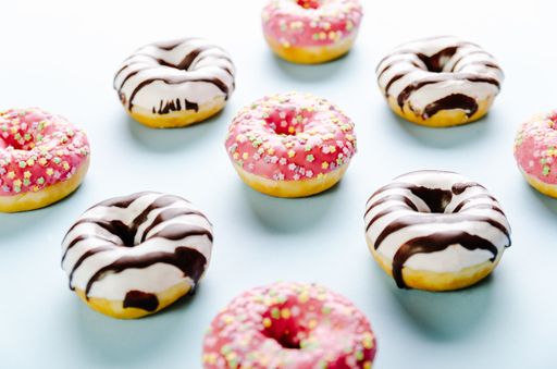 A closeup shot of delicious donuts on a light blue surface - perfect for a cool wallpaper