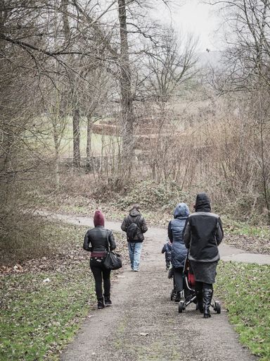 Group of people walking on a footpath at a park.