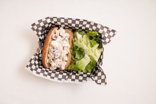 waldorf styled chicken salad sandwich with grapes and walnuts and caesar salad