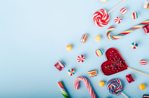 A closeup shot of candy canes and other candies on a light blue background - perfcet for a cool wallpaper