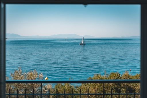 A white sailing boat is seen from a house overlooking the picturesque waters of Skopelos island in Greece