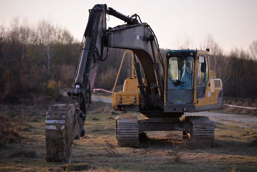 A closeup of a grungy excavator at a construction site