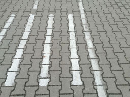 A closeup shot of white lines on a stone pavement outdoors