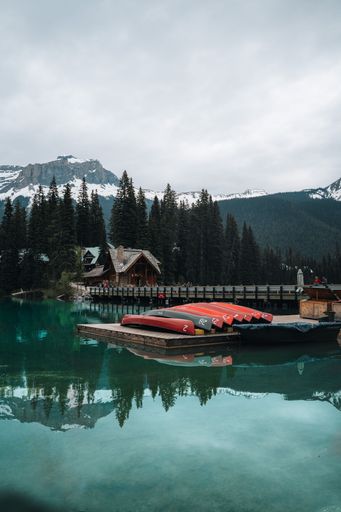 A beautiful view of a snowy mountain against a cloudy sky with a lake in the foreground