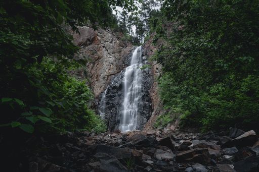 A beautiful view of a waterfall near the green trees in New Brunswick, Canada