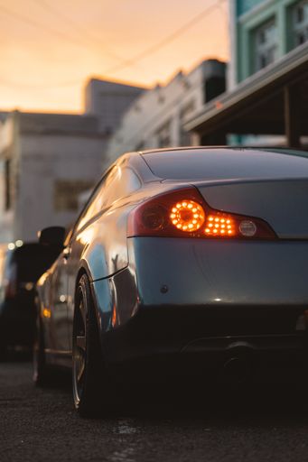 A backshot of a stylish silver metallic coupe car with the backlight on