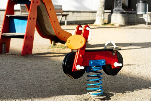A colorful motorcycle spring rocker in a children's park during dauylight
