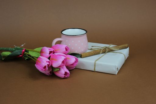 A top view of purple tulips with some sweets on a plate on a purple background - the present idea