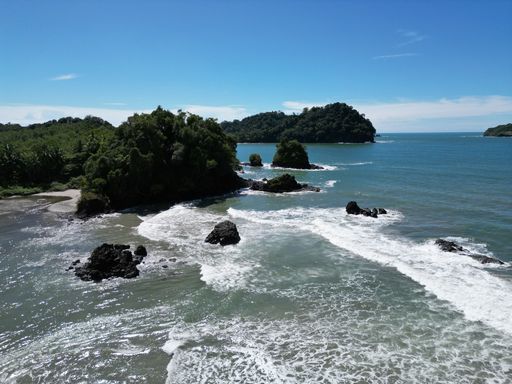 The sea waves splashing over the shore on a sunny day with a blue sky in the background in Costa Rica