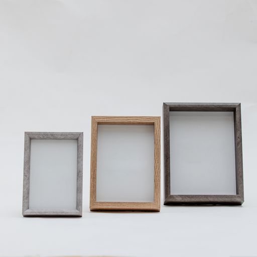 A vertical shot of wooden photo frames on an isolated white background