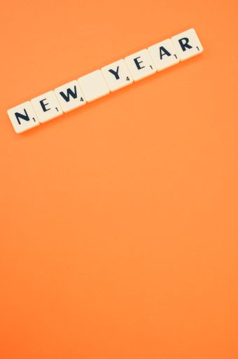 A vertical shot of "New Year" made of white tiles on orange background for a copy space
