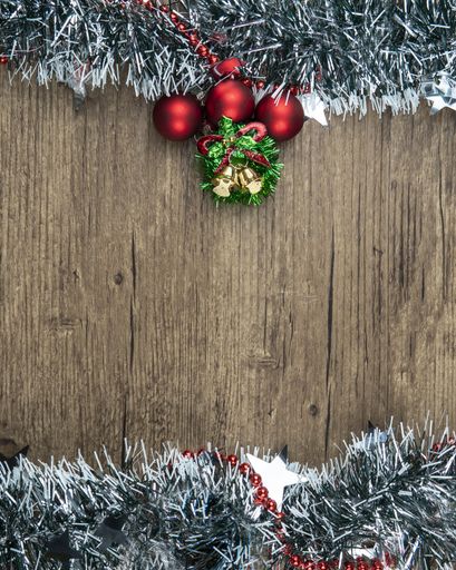 A vertical shot of a Christmas background with decorations on a wooden surface with a copy space