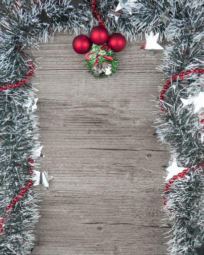 A vertical shot of a Christmas background with decorations on a wooden surface with a copy space
