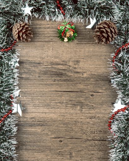 A vertical shot of a Christmas background with decorations on a wooden surface with a copy space