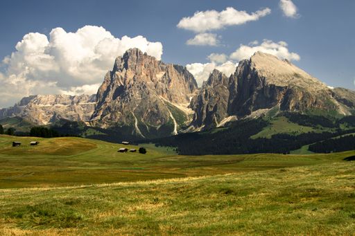 The Seiser Alm Alpine meadow with a cloudy blue sky in the background, Italy