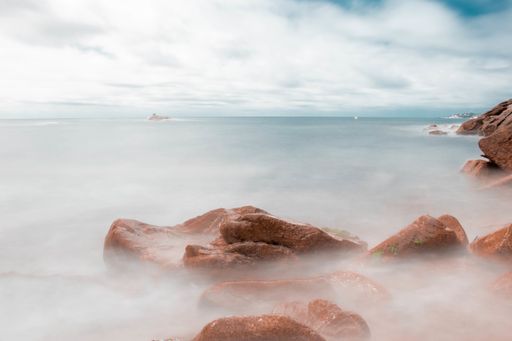 Playa con agua efecto seda con rocas de fondo