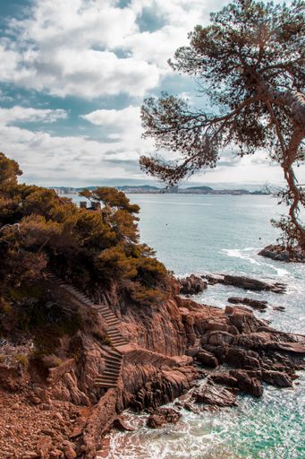 Vistas desde el camino de ronda de Sant Antoni de Calonge, mar en calma con unas escaleras para bajar a una cala
