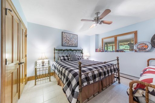 An interior shot of a bedroom with a ceiling fan and light blue walls.