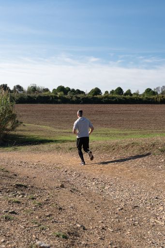 A vertical shot of an athlete running and working out on a warm sunny day